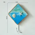 Gancho de pared estilo mediterraneo con concha estrella de mar y textura arena. - Blanco
