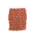 Detailed view of gold-tone stainless steel chain with vibrant red enamel beads on white spool. - Gold Chain with Red Beads