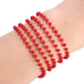 Detalle en primer plano de pulsera o collar con cadena de cuentas de vidrio de cristal rojo multibrand. - Rojo Brillante
