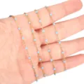 Close-up detail of stainless steel gold plated chain with light blue enamel beads for jewelry. - Gold Chain with Sky Blue Beads