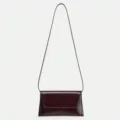 Close-up detail of the elegant patent leather flap shoulder bag with a slim strap. - Brown