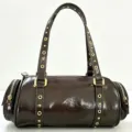 Brown patent leather bowling shoulder bag with vintage metal grommets and side zipper design. - Coffee