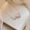 Primer plano detallado de un collar con colgante de flor de circonita brillante. - Estilo X1377 / Dorado
