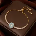 Elegante pulsera dorada con colgante de flor esmaltada en azul claro y cristales de circonita. - Pulsera Ajustable (TS0278) / Azul Dorado