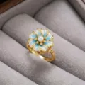 Vista de primer plano detallada de un elegante anillo floral dorado con pétalos esmaltados. - Anillo (J1186) / Azul-2