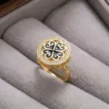 Elegante anillo de trébol dorado con circonitas cúbicas brillantes y detalles de esmalte negro. - Anillo (J0454) / Negro