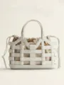 Detail view of the white leather cutout tote bag, showing the geometric grid design and pouch. - White