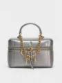 Close-up of metallic silver vanity bag with gold chain strap and cute charms detail. - Silver