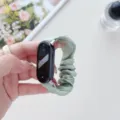 Detailed view of the green scrunchie watch strap, soft chiffon fabric texture for comfort. - Xiaomi Smart Band 8 / Verdant