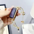 Detailopname van een elegante kralen metalen horlogeband compatibel met Apple Watch. - Donkere Ridder / Knoopparel Witte Parel Gouden Ketting