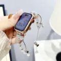Gedetailleerde close-up van de metalen kralen horlogeband met witte kralen en sterhanger. - Donkere Ridder / Knoopparel Witte Parel Zilveren Ketting