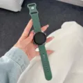 Vista ravvicinata del cinturino per smartwatch in silicone verde scuro con motivi floreali. - Verde pino