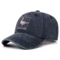 Primo piano del dettaglio dell'oca ricamata e del testo sul cappello in denim scuro - Regolabile 55-59cm / Blu Marino Lavato