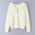 Close-up detail of women's cream white hooded zip-up knit sweater with ribbed texture. - S / White