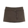 Brown houndstooth fabric detail, thin waist cord and metal buckle close-up view of the skirt. - XS / Bottoms / Brown Plaid