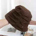Close-up detail of retro brown suede bucket hat featuring pleated design and metal accent. - Adjustable / Coffee