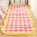 Detailed view of a soft pink and white checkered bedside rug with a cozy yellow wavy border. - 40x120cm / Woven Lemon Pink