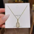 Detailaufnahme einer eleganten Kürbis-Anhänger-Halskette mit weißem Chalcedon und edler Goldkette. - Gold