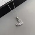 Silberfarbene Halskette mit hohlem Herzanhänger und funkelnden Zirkoniasteinen elegantes Design. - Silber