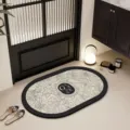 Moderne antislip badmat met prachtig bladmotief en Garden logo voor de entree thuis. - Regenwoud