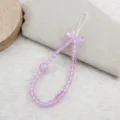 Detailed close-up of a sweet pink beaded phone strap featuring a cute bow and charming design. - Purple Bowknot Panda