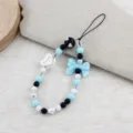 Detailed view of sweet blue and black beaded phone strap, bow charm and love heart accent. - White Heart Blue Bowknot