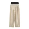 Detailed view of women's high-waist wide-leg trousers in beige with black waistband. - XS / Bottoms / Off White