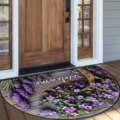 Detail view of the half-round floral doormat with welcome text placed at the wooden porch. - Lavender