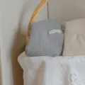 Dettaglio abbigliamento in maglia per neonati, tessuto morbido accogliente, stile minimalista. - Grigio melange