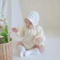 Infant waffle knit baby romper detail shot, soft newborn bodysuit with cute matching bonnet. - One Size / Hat / Apricot