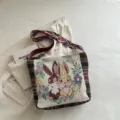 Gewebte Segeltuch-Umhängetasche mit süßem Cartoon-Kaninchen- und Blumenmuster für den Alltag. - Kaninchen
