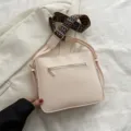 Beigefarbene minimalistische Umhängetasche mit gemustertem breiten Riemen für Pendler. - Weiß