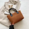 Modische braune Cord Handtasche für Damen mit schwarzen Griffen und goldener Kette. - Braun