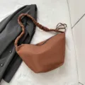 Minimalistische braune Canvas-Knödel-Umhängetasche mit Faltenriemen für den Alltag. - Braun