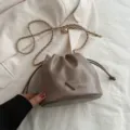 Schicke PU Leder Beuteltasche mit Metallkettenriemen und stilvollem dreieckigem Detail Damen. - Khaki