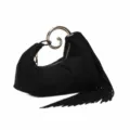 Detail view of black velvet handbag featuring unique gold spiral handle and elegant fringe trim. - Black
