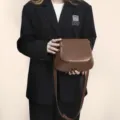 Vue détaillée du sac selle en cuir PU marron, bandoulière élégante et design épuré. - Marron