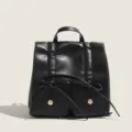 Sac à dos élégant en cuir noir avec nœud mignon et poches avant pour un usage quotidien. - Noir