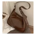 Sac porté épaule hobo en cuir marron foncé chic avec large bandoulière à boucle et fermeture éclair. - Café
