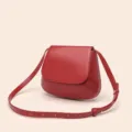 Vue détaillée du sac bandoulière rouge en cuir PU, montrant les coutures et le rabat. - Rouge