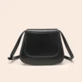 Détail de sac de selle classique en cuir PU noir, design de rabat incurvé élégant pour femme. - Noir