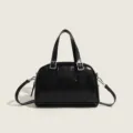 Black vintage style PU leather pillow handbag with top handles and adjustable shoulder strap. - Black