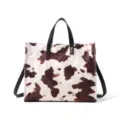 Detailed view of the stylish cow print plush tote bag with black handles and spacious capacity. - Floral
