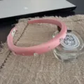 Primo piano di un cerchietto in raso rosa decorato con stelle di cristallo scintillanti. - Rosa Pompelmo
