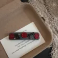 Detailopname van vintage grijze haarspeld met rode smileygezichten en zwarte strikdetails. - Lachend Gezicht BB Clip / 7.5cm