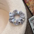 Vista dettagliata di un elegante elastico per capelli in raso grigio-azzurro. - Stile con Perle / Azzurro