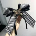 Meraviglioso dettaglio del fiocco pied de poule bianco e nero con spilla in cristallo. - Strass champagne