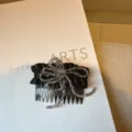 Primo piano dettaglio pettine per capelli fiocco perle cristallo, accessorio elegante. - nero classico