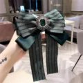 Green herringbone bow brooch with vintage crystal rhinestone gemstone center, elegant clothing accessory. - Green