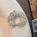 Detailed shot of a Korean style mesh polka dot hair scrunchie with delicate ruffles. - Oval Bead / Off White